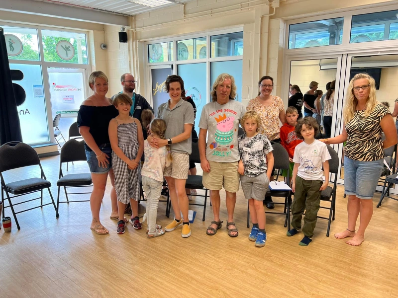 Parents and their children stood in a line looking at the camera